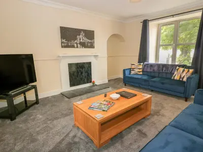 a living room with a blue couch and a coffee table at West Morton House in Thornhill