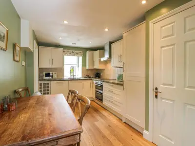a kitchen with a wooden table and a wooden floor at The Suite in Thornhill