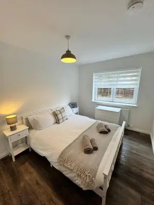 a bedroom with a large bed with two towels on it at Inchconnachan Apartment in Bonhill