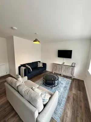 a living room with a couch and a tv at Inchconnachan Apartment in Bonhill