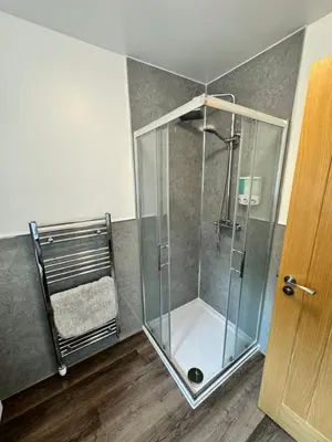 a shower with a glass door in a room at Inchchlonaig Apartment in Bonhill