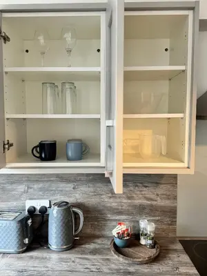 a kitchen cabinet filled with lots of dishes at Inchchlonaig Apartment in Bonhill