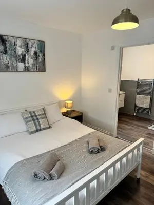 a bedroom with a bed with towels on it at Inchchlonaig Apartment in Bonhill