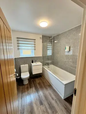 a bathroom with a toilet and a tub and a sink at Inchchlonaig Apartment in Bonhill