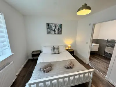 a bedroom with a bed with two towels on it at Inchchlonaig Apartment in Bonhill
