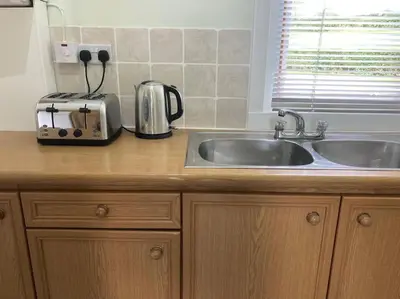 a kitchen counter with a sink and a toaster at Lednabra Cottage in Drymen