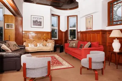 a living room with a red couch and chairs at Garmoyle House & Garmoyle Mid Cottage in Dumbarton