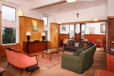 a living room with a cross on the wall at Garmoyle House & Garmoyle Mid Cottage in Dumbarton