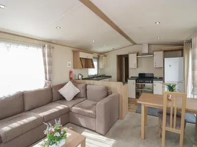 a living room and kitchen with a couch and a table at Elm in Denny