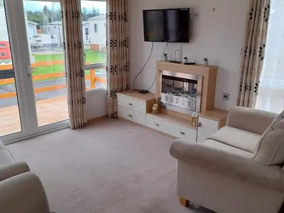 a living room with two chairs and a tv at Oak in Denny