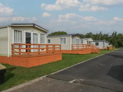 a house with a wooden deck next to a row of houses at Oak in Denny