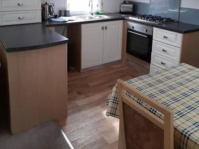 a kitchen with white cabinets and a counter top at Oak in Denny
