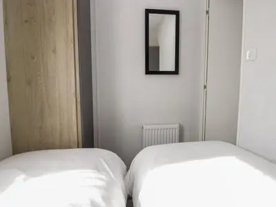 two white beds in a room with a mirror at Ash in Denny