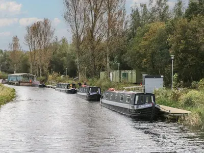 three boats are docked on a river at Ash in Denny