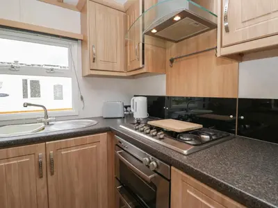 a kitchen with a stove and a sink at Willow in Denny