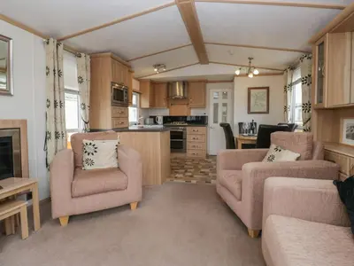a living room with two chairs and a kitchen at Willow in Denny