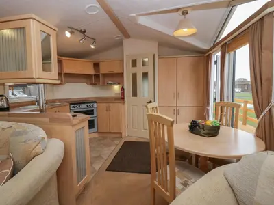a kitchen and dining room with a table in a caravan at Birch in Denny