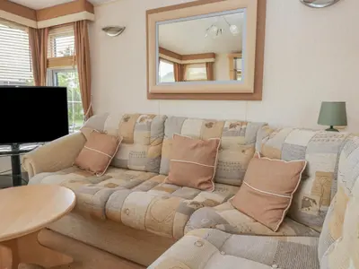 a living room with a couch and a mirror at Birch in Denny