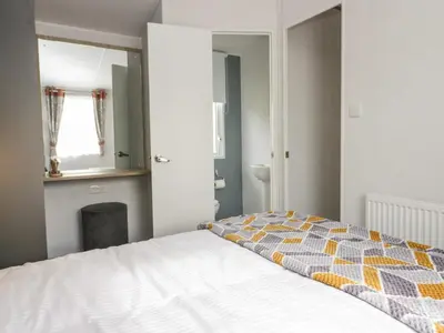 a bedroom with a bed and a window and a mirror at Hazel in Denny