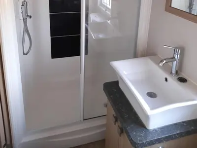 a bathroom with a white sink and a shower at Yew in Denny
