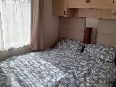 a bed in a small room with a window at Yew in Denny