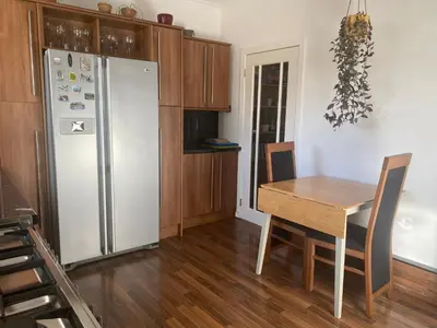 a kitchen with a wooden table and a refrigerator at Frans Place in Edinburgh