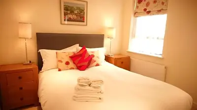 a bedroom with a white bed with towels on it at Violet Bank Apartment New Town in Edinburgh