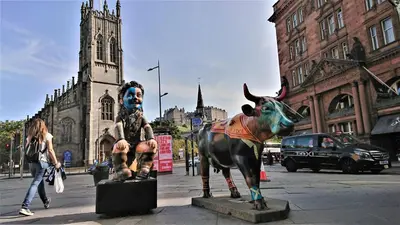 a statue of a woman next to a statue of a bull at Violet Bank Apartment New Town in Edinburgh
