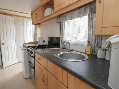 a kitchen with a sink and a stove at Holly in Denny