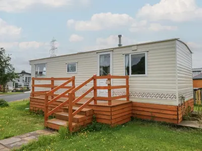 a mobile home with a porch and a deck at Holly in Denny
