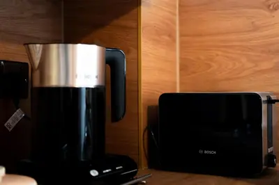 a coffee pot sitting next to a microwave at 24 Kingsford Court in Newton Mearns