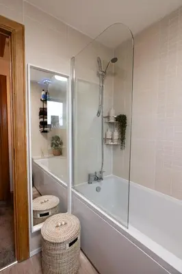 a bathroom with a shower and a tub with two stools at 24 Kingsford Court in Newton Mearns