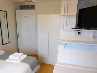 a bedroom with a bed and a flat screen tv at No 52 - Newly refurbished 3 bedroom home in East Kilbride in East Kilbride