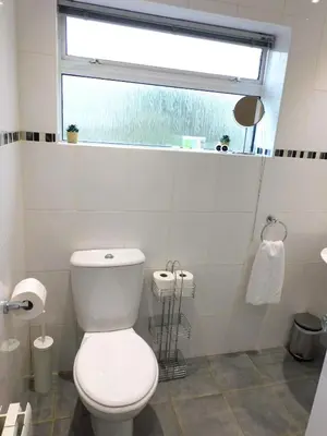 a white bathroom with a toilet and a window at No 52 - Newly refurbished 3 bedroom home in East Kilbride in East Kilbride