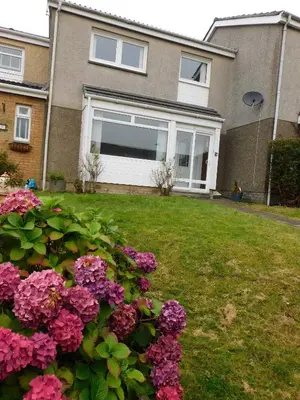 a house with a window and flowers in the yard at No 52 - Newly refurbished 3 bedroom home in East Kilbride in East Kilbride