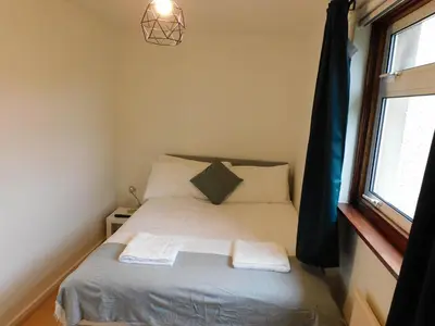 a bedroom with a bed with two towels on it at No 52 - Newly refurbished 3 bedroom home in East Kilbride in East Kilbride