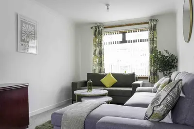a living room with a couch and a table at Redding House in Falkirk