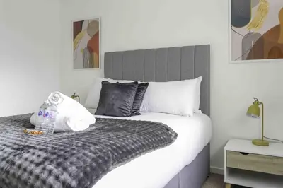a bedroom with a bed with a black and white comforter at Redding House in Falkirk