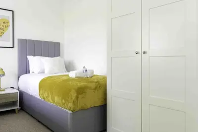 a bedroom with a bed and a closet at Redding House in Falkirk