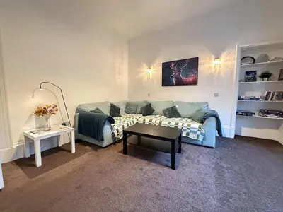 a living room with a couch and a table at 2 Bed Flat - Street Parking in Glasgow