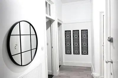 a hallway with a round mirror on the wall at 2 Bed Flat - Street Parking in Glasgow