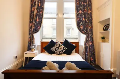 a bedroom with a bed with pillows and a window at 2 Bed Flat - Street Parking in Glasgow