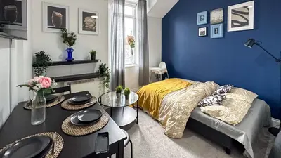 a bedroom with blue walls and a bed and a table at Flat for 6 guests near Glasgow, Loch Lomond in Dumbarton