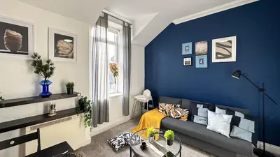 a living room with a couch and a blue wall at Flat for 6 guests near Glasgow, Loch Lomond in Dumbarton