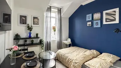 a blue bedroom with a bed and a table at Flat for 6 guests near Glasgow, Loch Lomond in Dumbarton