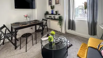 a living room with a table and a dining room at Flat for 6 guests near Glasgow, Loch Lomond in Dumbarton