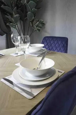 a wooden table with plates and wine glasses on it at Granby House in Livingston