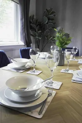 a table with plates and wine glasses on it at Granby House in Livingston