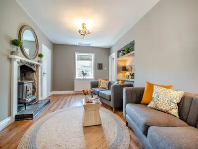 a living room with two couches and a fireplace at North Lodge in Colintraive