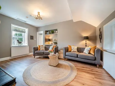a living room with two couches and a table at North Lodge in Colintraive